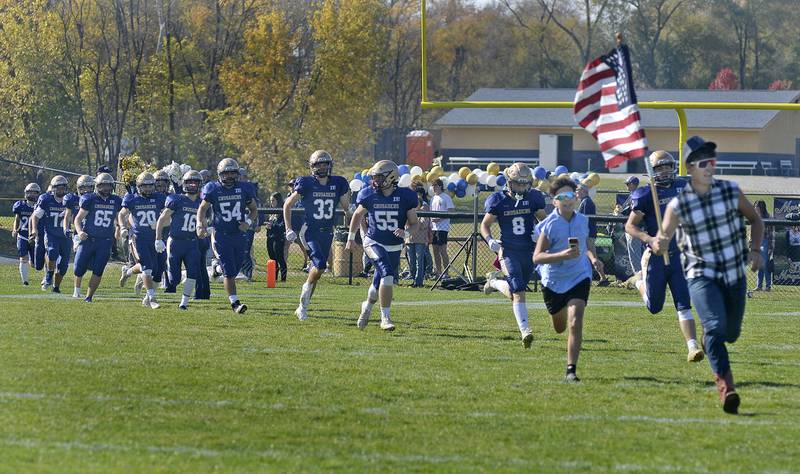 The Marquette Crusaders run out onto the field at during the Class 1A first round playoff game on Saturday, Oct. 29, 2022 at Gould Stadium in Ottawa.