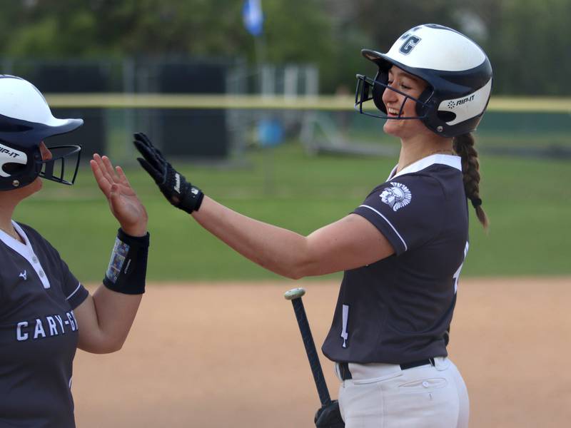 Cary-Grove’s Maddie Crick is greeted after a home run against Burlington Central in varsity softball at Cary Monday.