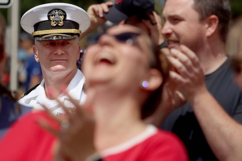 US Navy serviceman Jonathan Grell of Algonquin watches the parade pass as others enjoy the Memorial Day scene in Huntley Monday.