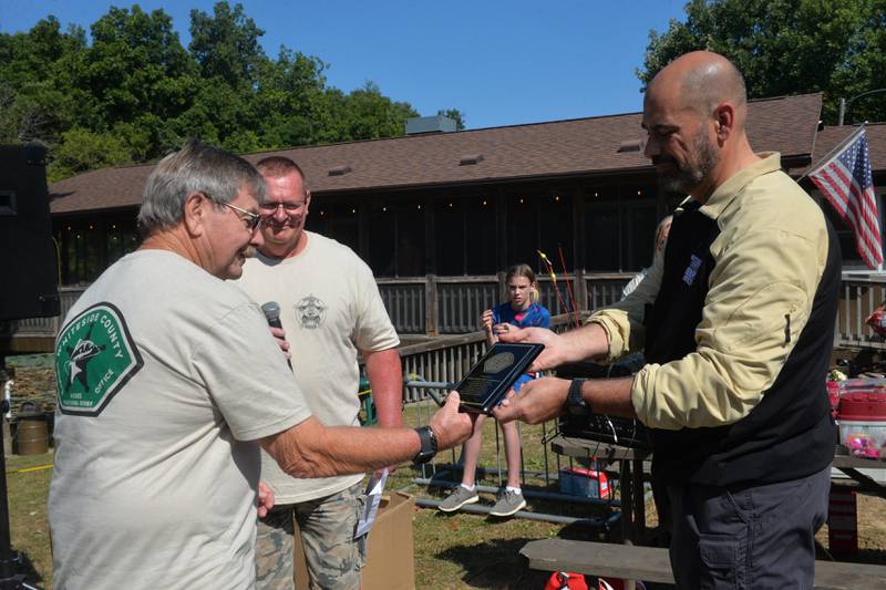 Fomer Whiteside County Sheriff Roger "Skip" Schipper accepts an appreciation plaque from current sheriff John Booker and detective Michael Leighton at the Whiteside County Sheriff Office and Mounted Patrol's annual fishing derby at Morrison-Rockwood State Park in Morrison on Saturday, Sept. 9, 2023.