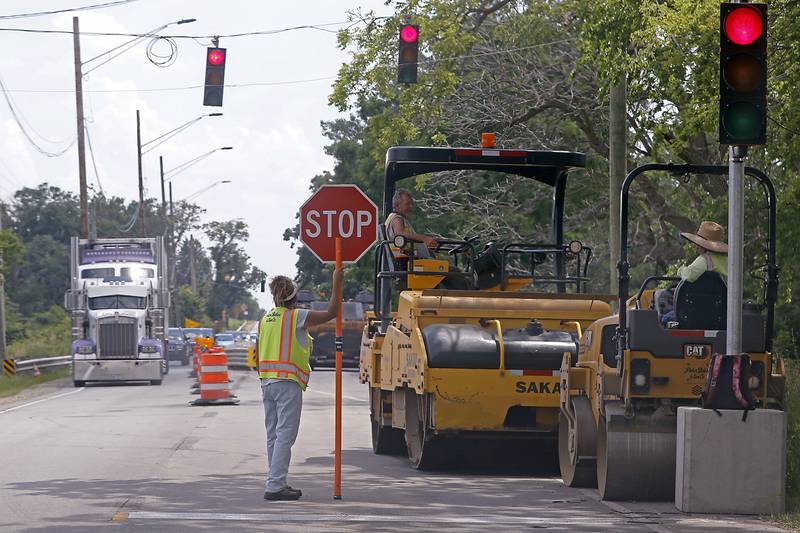 Construction workers take a break in the shade on Monday, June 17, 2024, as they work on replacing a bridge on Illinois Route 47 north of Woodstock.