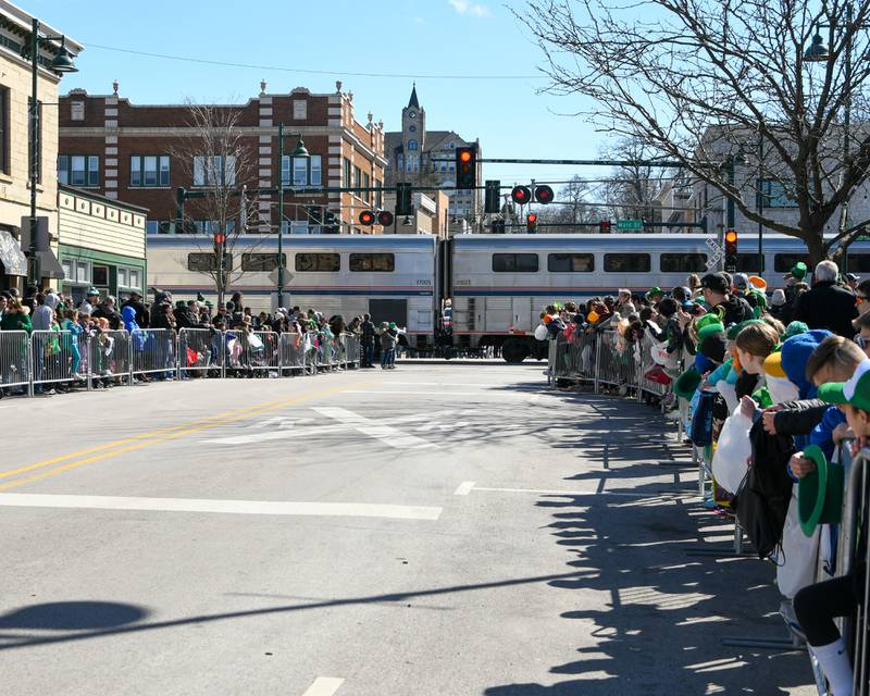 A Metra train passes the parade route before the start of the St. Patrick’s Parade on Saturday March 9, 2024, in Downtown Lemont.