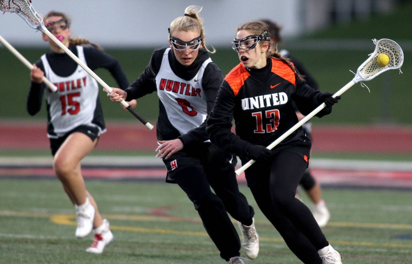 Huntley’s Lauren Cardinal, center, pursues Crystal Lake Central’s Ella Madalinski, right, in varsity lacrosse at Huntley Wednesday.