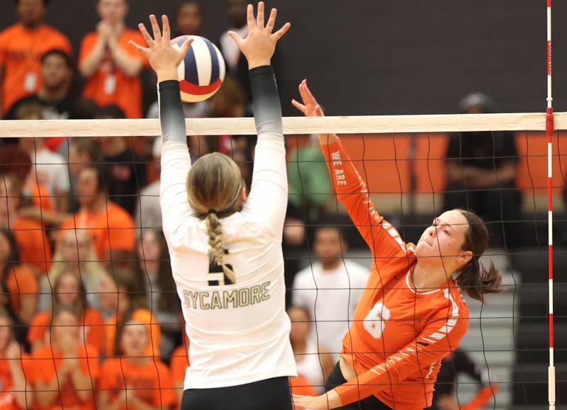 DeKalb's Adisyn Galijatovic spikes the ball as Sycamore's Kylie Walsh goes for the block during their match Wednesday, Aug. 28, 2024, at DeKalb High School.