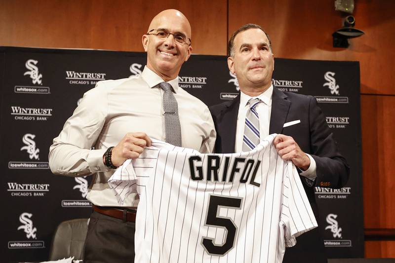 New Chicago White Sox manager Pedro Grifol, left, is given a White Sox jersey by general manager and senior vice president Rick Hahn, right, during a news conference, Thursday, Nov. 3, 2022, in Chicago.