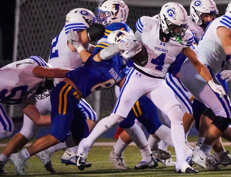 Wheaton North's Nick Sanguinetti (8) attempts to strip the ball from Geneva’s Troy Velez (4) during a football game at Wheaton North High School on Friday, Oct. 6, 2023.