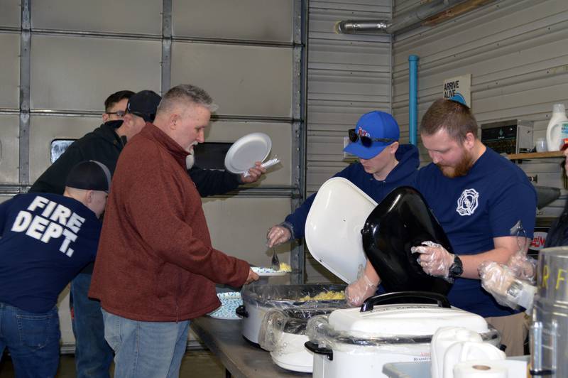 Eric Badertscher, of Leaf River, left, is served food by Leaf River Fire Protection District volunteers on Feb. 25, 2023, during the annual Leaf River Firemen's Pancake Supper. A little over 700 people attended the fundraiser at the Leaf River fire station, raising $2,050.