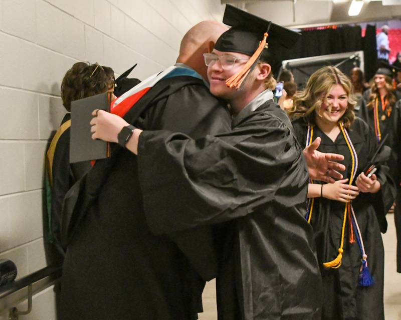 Parker Sands gets a hug from Steve Byers, a DeKalb District 428 school board member, after Parker graduated during the DeKalb High School 2024 commencement ceremony on Saturday, May 25, 2024, at the Northern Illinois University Convocation Center in DeKalb.