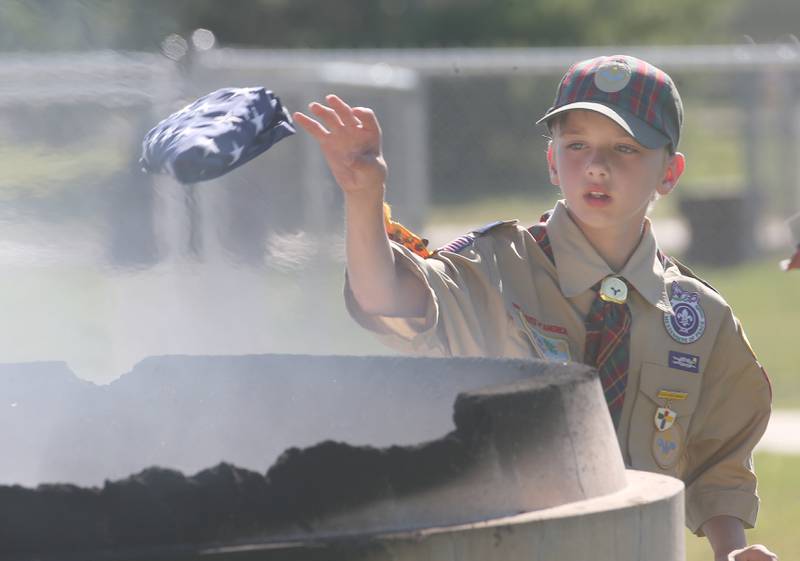 Boyscout Evan Hall  tosses an American Flag into a burning cauldron during a  Flag Retirement Ceremony on Friday, June 14, 2024 at Veterans Park in Peru.  The ceremony always takes place on Flag Day. It began as a Eagle Scout project for area boy scouts about 30 years ago. Boy Scouts from Peru's Troop 123 and Peru Cub Scouts from Pack 3709 were on hand to help with the ceremony. When an American Flag gets torn and tattered, Flag etiquette requires it to be proper disposed in a burning cauldron.