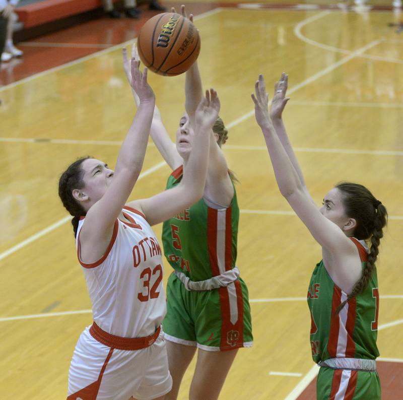 Ottawa’s Mary Stisser gets a shot away over the block attempts by LaSalle Peru’s Addison Urbanski and Bailey Pode Thursday during the 1st period at Ottawa.