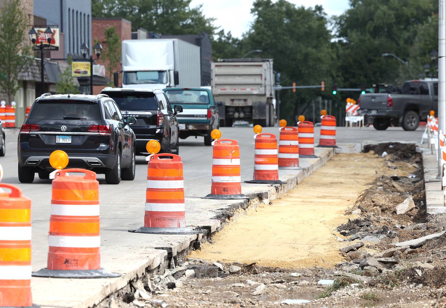 Cars pass by the sidewalk construction Wednesday, Aug. 28, 2024, on Main Street in Genoa.