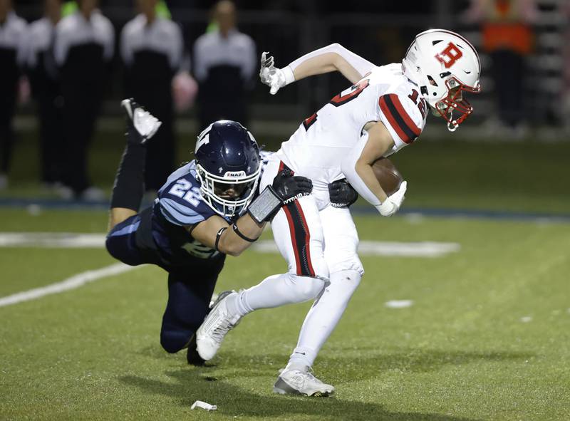 Benet's John Ericson (12) is stopped by Nazareth's Anthony Donato (22) during the varsity football game between Benet and Nazareth academies on Friday, Oct. 18, 2024 in La Grange Park.