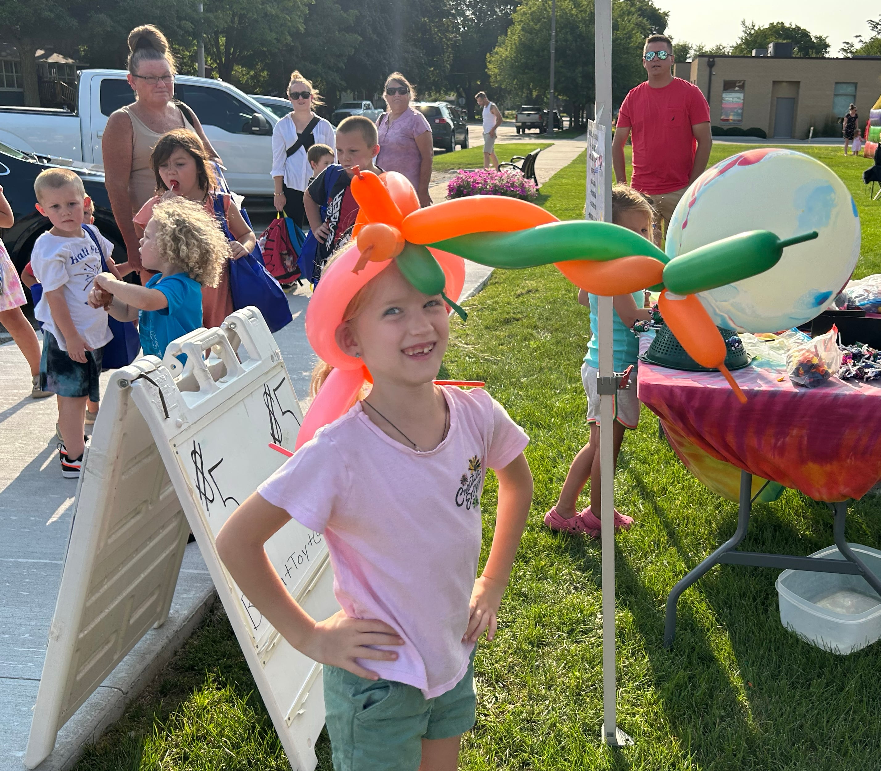 Ariya Foster, 8, of Sterling, shows off her unicorn balloon hat made by Jackie Armstrong aka "Twinkie the Balloon Twister" of Clinton, Iowa, at one of the booths at Prophetstown's Fourth Friday on Friday, July 26, 2024.