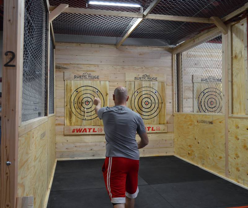 John Vos, of Oregon, lands an ax in the target for three points during the grand opening of Rustic Ridge Axe Throwing on May 28. The business is located at 117 N. 4th St., Oregon, and is affiliated with the World Axe Throwing League.