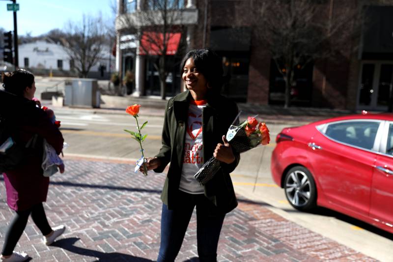 Random Acts Matter volunteer Shamberi Smith (left) hands out orange roses in St. Charles as part of Random Acts of Kindness Week on Wednesday, Feb. 14, 2024.