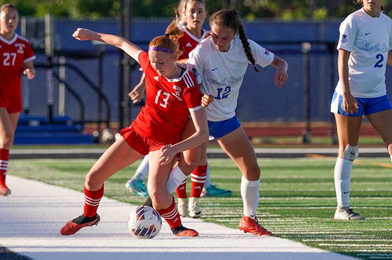 St. Charles North's Kyra Treanor (12) challenges Naperville Central's Emma Russell (13) for the ball during a Class 3A St. Charles North Supersectional soccer final match at St. Charles North High School on Tuesday, May 28, 2024.
