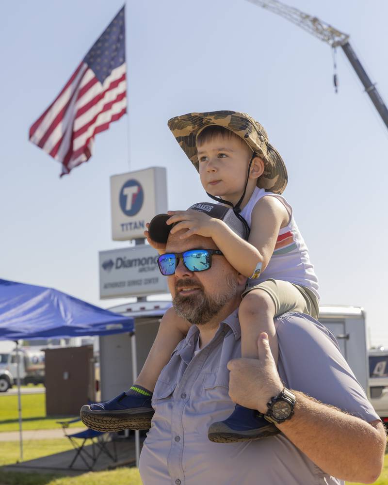 Patrick Lesher and his son Max look on as airplanes on the ramp start up at Illinois Valley Regional Airport for the TBM Avenger Reunion and Salute To The Veterans on May 18, 2024.