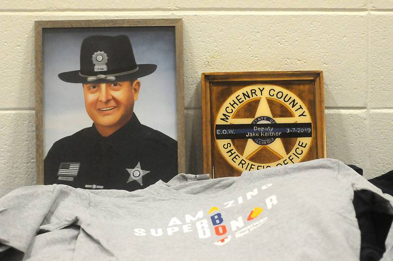 T-shirts for blood donors lay in front of of a portrait of McHenry County Sheriff's Deputy Jake Keltner during third annual Jake Keltner Memorial Blue Blood Drive on Law Enforcement Appreciation Day on Sunday, Jan. 9, 2022, at the Sage YMCA in Crystal Lake. Keltner was killed in the line of duty serving an arrest warrant in Rockford in March 2019. All 230 appointments to donate blood were filled this year.