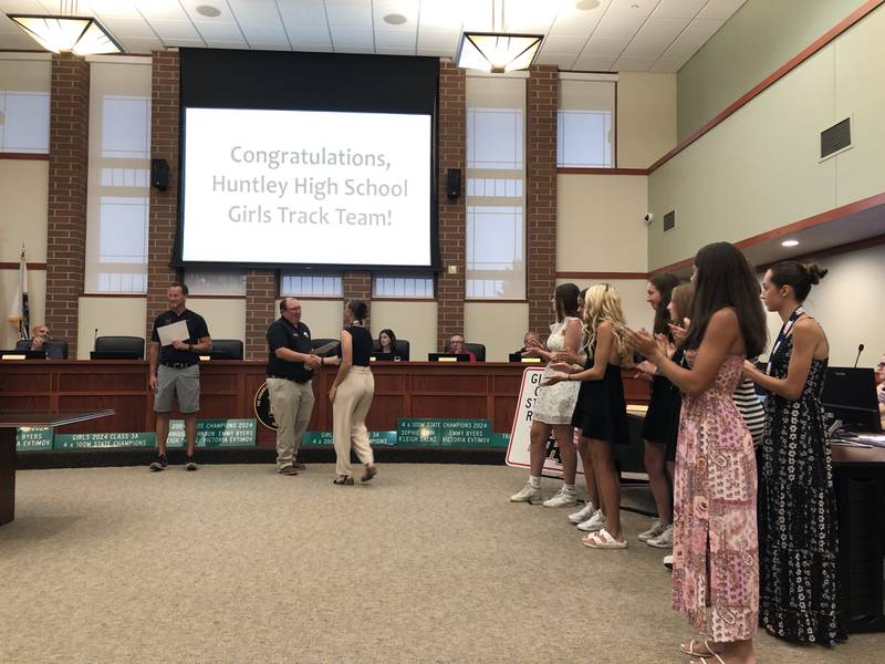 Huntley Village President Tim Hoeft presents a certificate to Emmy Byers at the Huntley Village Board meeting July 25, 2024 in recognition of the Huntley High School track team's state titles.