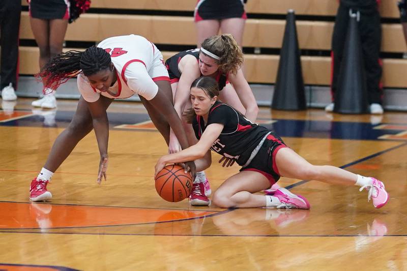 Benet’s Lindsay Harzich (12) dives for a loose ball against Bolingbrook's Jasmine Jones (40) during a Oswego semifinal sectional 4A basketball game at Oswego High School on Tuesday, Feb 20, 2024.