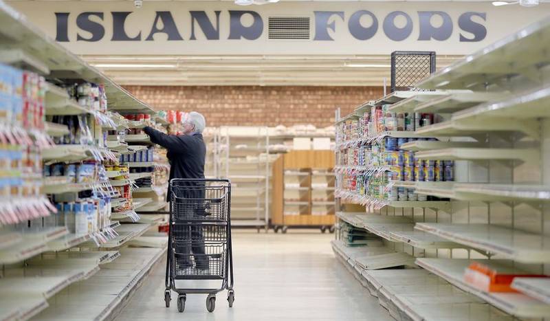 Jeff Hollander who has worked at Island Foods for more than 10 years moves stock to different shelves Wednesday. After nearly 51 years, the Island Lake grocer will be closing as the owners retire.