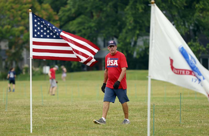 Rudy Keller oversees the set up for the Field of Honor, a display of 2,024 American flags arranged in 25 neat rows Saturday, June 29, 2024 at Seven Gables Park in Wheaton. Keller has been putting up flag installations around DuPage County for years.