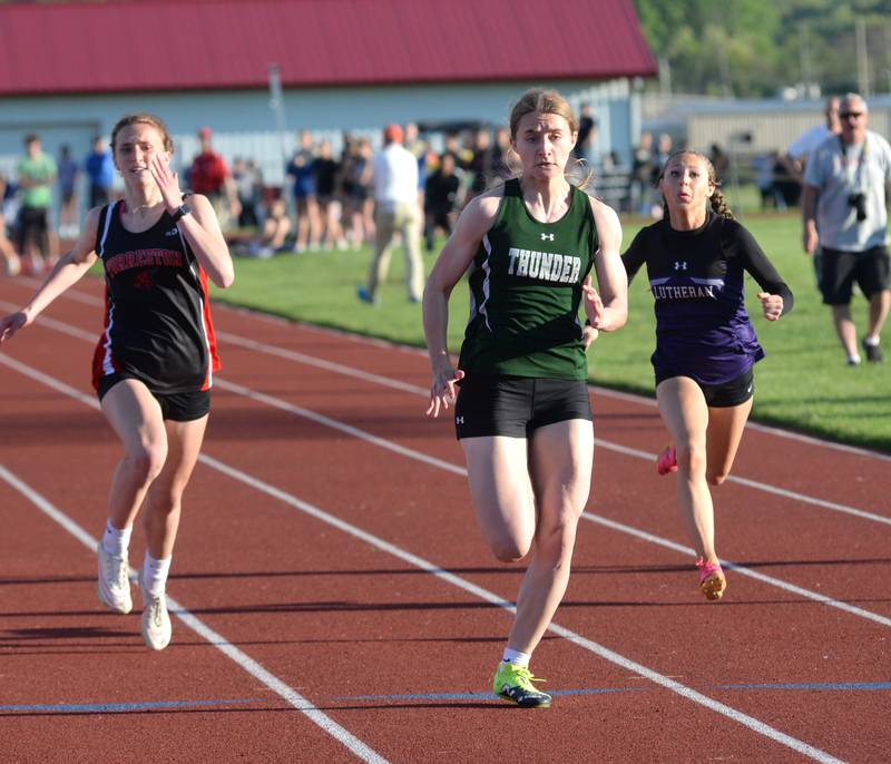 West Carroll's Emma Randecker (center) heads to the finish line in the 100 meters at the 1A Oregon Sectional on Friday. May 10, 2024. Randecker won the race in 12.43 seconds to qualify for the state finals at Easstern Illinois University in Charleston. Also pictured is Forreston-Polo's Bree Schneiderman (left) who finished second and also qualified for the state meet.