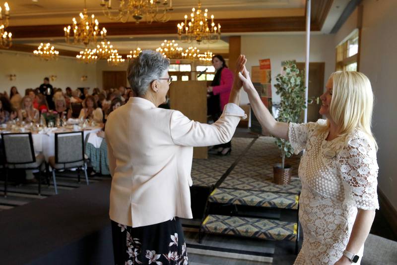 Award recipient Trudy Wakeman receives a “high five from Northwest Herald publisher Laura Shaw as Wakeman is called to the stage during the Northwest Herald's Women of Distinction award luncheon Wednesday June 5, 2024, at Boulder Ridge Country Club, in Lake in the Hills. The luncheon recognized 11 women in the community as Women of Distinction.