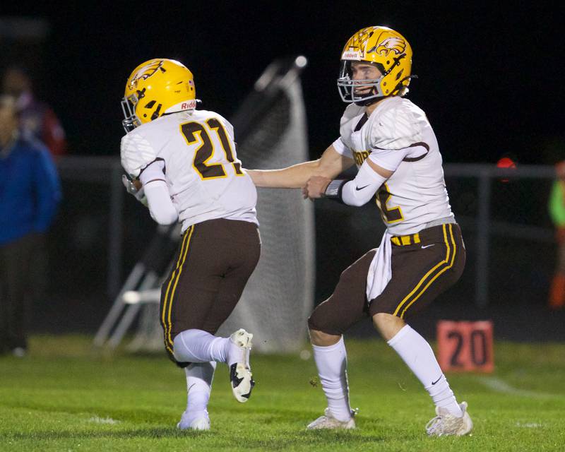 Jacobs Connor Goehring hands the ball off to Michael Cannady against Burlington Central on Friday, October 4,2024 in Burlington.