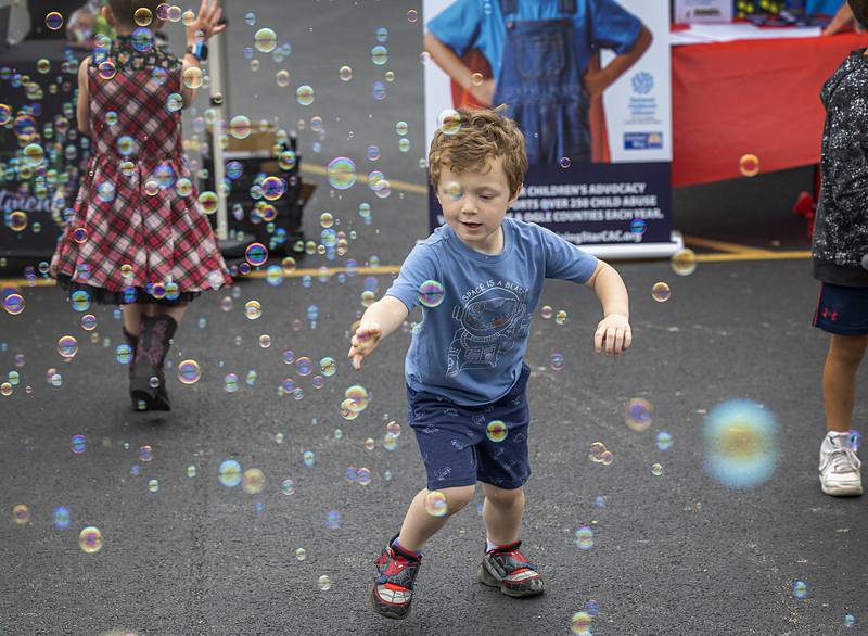 Joe Dowdall, 4, of Dixon swipes at bubbles while attending the Dixon Summer Block Party Saturday, June 8, 2024. The party was held at the Plaza North Shopping Center in Dixon.