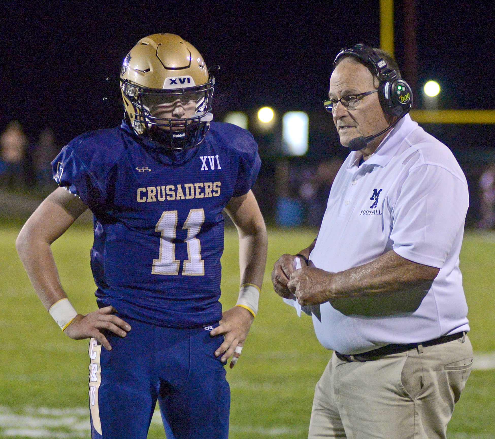 Marquette Coach Tom Jobst talks over a play with quarterback Anthony Couch during a time out Friday against Ridgewood in the 1st quarter.