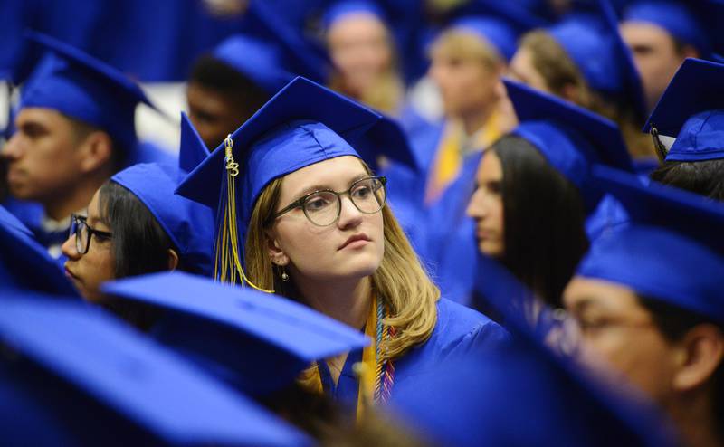 Joe Lewnard/jlewnard@dailyherald.com
A graduate looks toward friends walking past during the presentation of diplomas at the Wheaton North High School graduation, held at the College of DuPage in Glen Ellyn Saturday.