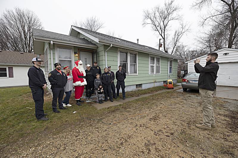 Devin Teske snaps a picture of Rock Falls police and fire representatives and members of the Jablonski family Friday, Dec. 22, 2023 after a delivery for Operation Santa Claus.