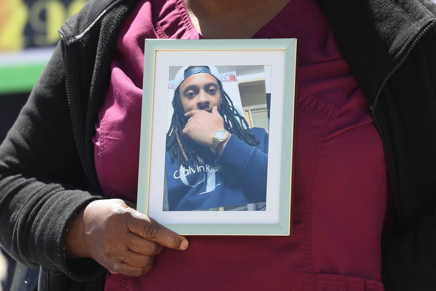 Charlene Edmond holds a photo of her son Jamal Smith during a gathering outside Will County courthouse to remember Jamal on Monday, April 8, 2024 in Joliet.