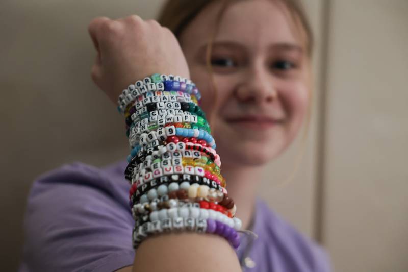 Violet Carrick, 13-years old, shows off her collection of Taylor Swift bracelets at the Taylor Swift fan party hosted by the Lockport Township Park District on Saturday, Feb. 10, 2024 in Lockport.