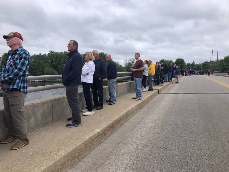 Attendees listen from the Fox River bridge during the Johnsburg Memorial Day ceremony Monday May 27, 2024.