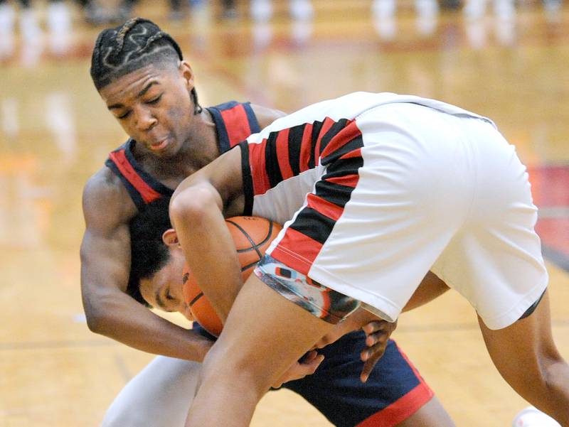West Aurora's Jayvyn Marion (left) fights for the ball against Bolingbrook's Davion Thompson during a class 4A regional championship basketball game at Yorkville High School on Friday, Feb. 23, 2024.