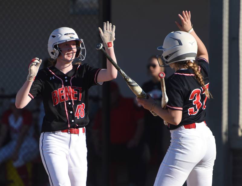 Benet's Marikate Ritterbusch (48) and Gianna Horejs high-five after a run against Naperville Central during Wednesday’s softball game in Naperville.