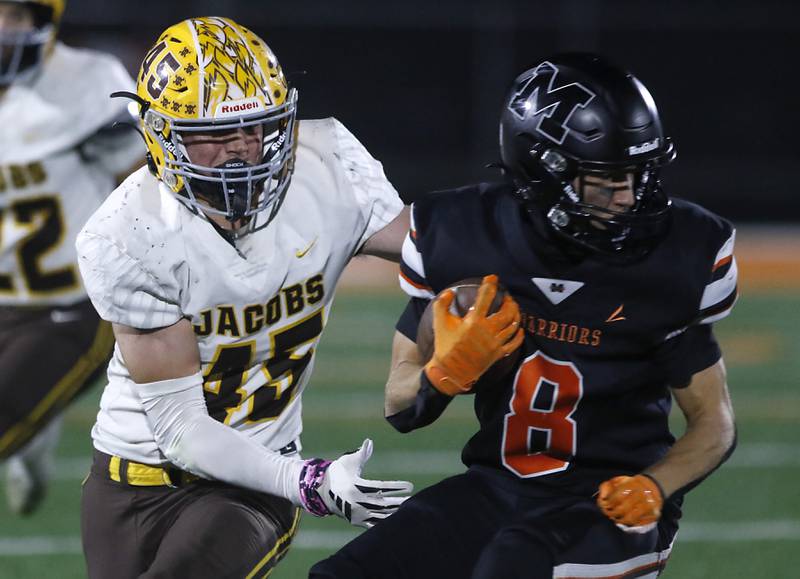 McHenry's Jeffry Schwab tries to spin away from Jacobs' John Coates as he returns a kick during a Fox Valley Conference football game on Friday, Oct. 18, 2024, at McKracken Field in McHenry.