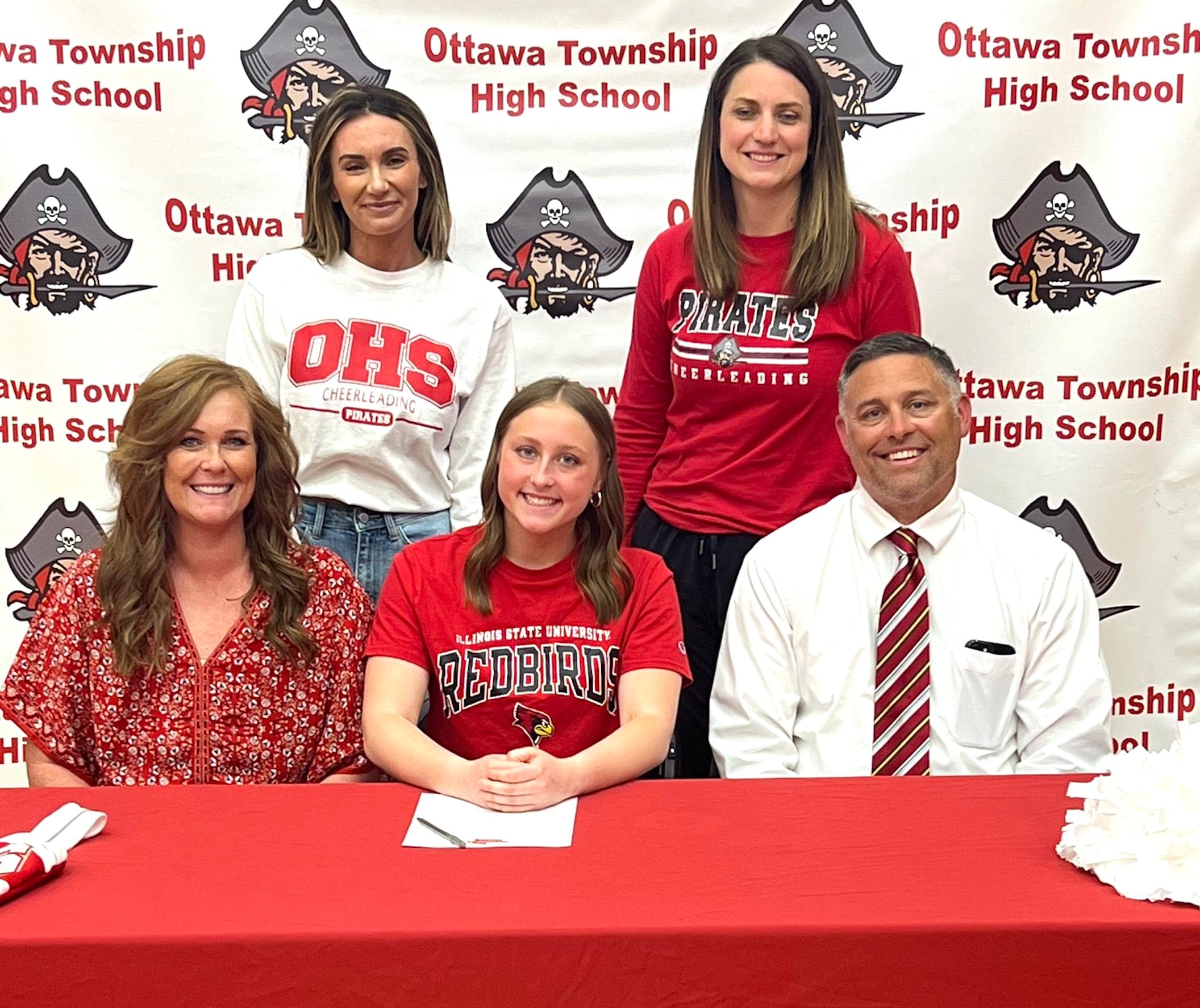 Ottawa’s Cabella DeBernardi has signed to continue her education at Illinois State University in Normal and her cheer career with the Redbirds. She is pictured here at her signing ceremony alongside her parents with her cheer coaches standing behind.