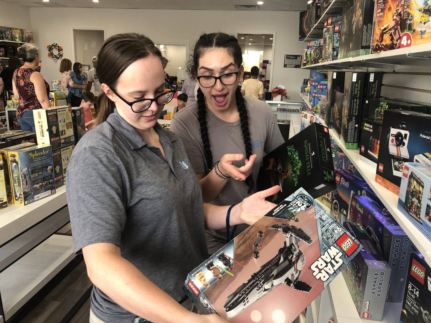 Grace Null and Melanie Kovatch check out the Lego sets at The Pieceful Project in Cary during its ribbon cutting event on Wednesday, July 24, 2024. The women said they are excited to have a place to shop for their Lego sets and projects.