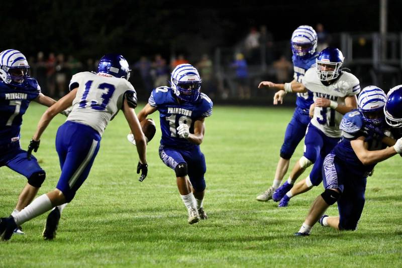 Princeton's Kaydin Gibson (12) looks for running space against the Newman defense and John Rowzee Friday night at Bryant Field. The Tigers won 27-14.