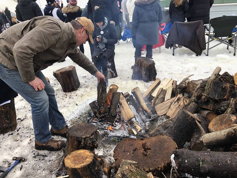 Matt Tegelman adds wood to his fire at the Norge Ski Jump tournament Jan. 27, 2024.