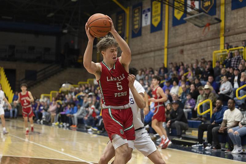 LaSalle-Peru’s Seth Adams protects the ball late in the game against Dixon Wednesday, Feb. 21, 2024 at the Sterling class 3A basketball regional.