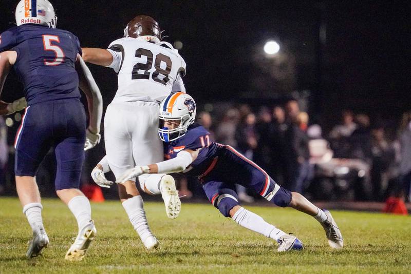 Oswego’s Mariano Velasco (12) tackles Joliet Catholic's Nate Magrini (28) during a football game at Oswego High School on Friday, Sep 6, 2024.