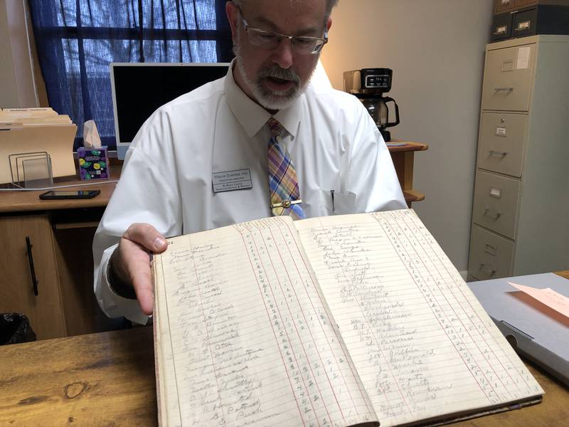 Wayne Duerkes, executive director of the McHenry County Museum and Historical Society, displays the Marengo 1893 census count book, recently restored, rebound and donated to the society.