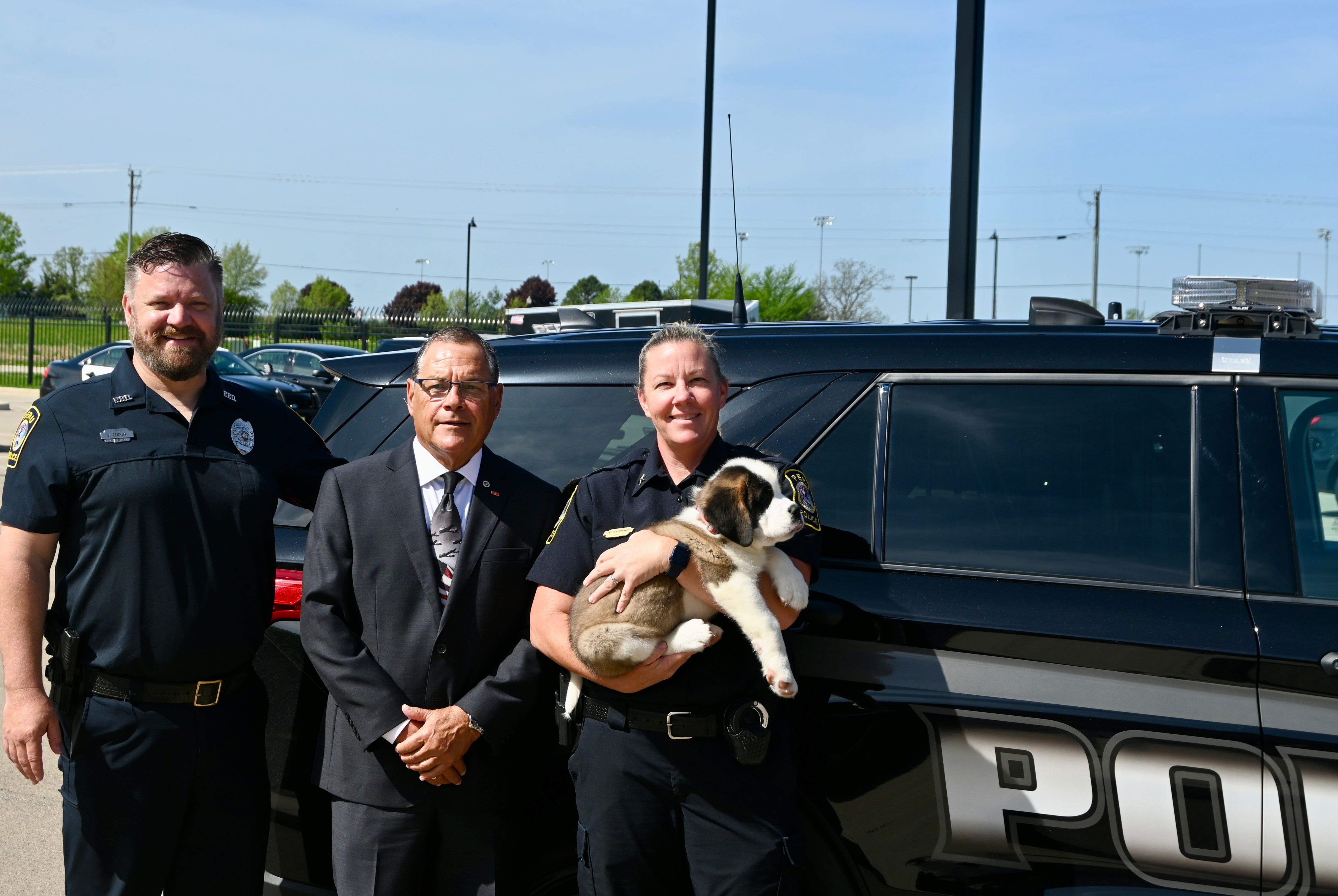 School Resource Officer Brian Zebron with La Salle State's Attorney Joe Navarro and Peru Police Chief Sarah Raymond holding Peru's newest recruit Haven.