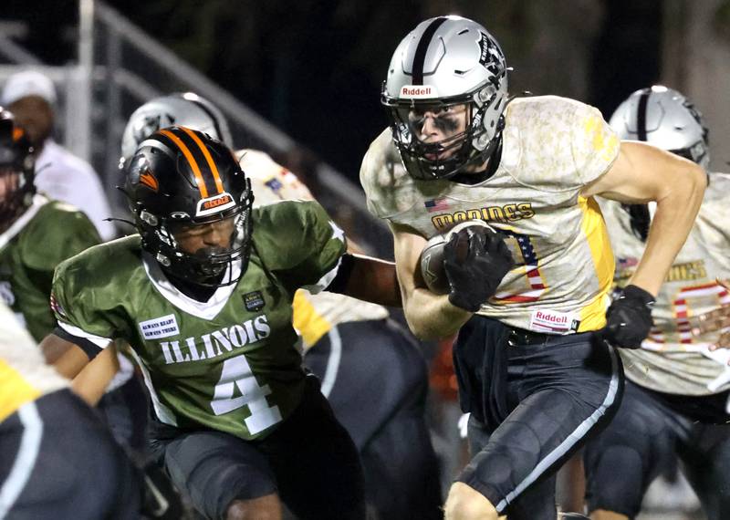 Kaneland's Carter Grabowski carries the ball as DeKalb's Damarrion Belue tries to make the tackle during their game Friday, Sept. 13, 2024, at Kaneland High School in Maple Park.