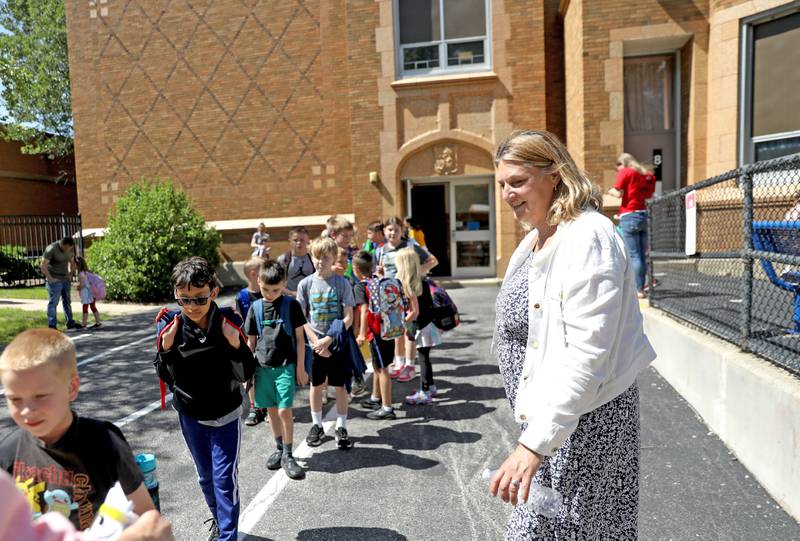 Lincoln Elementary School Principal Michelle Woodring greets students as they leave for the day in St. Charles. The building will house professional development and the school district’s transition program in the fall.