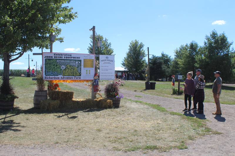 A family looks over the map of the Richardson Adventure Farm's 28-acre corn maze before heading in.